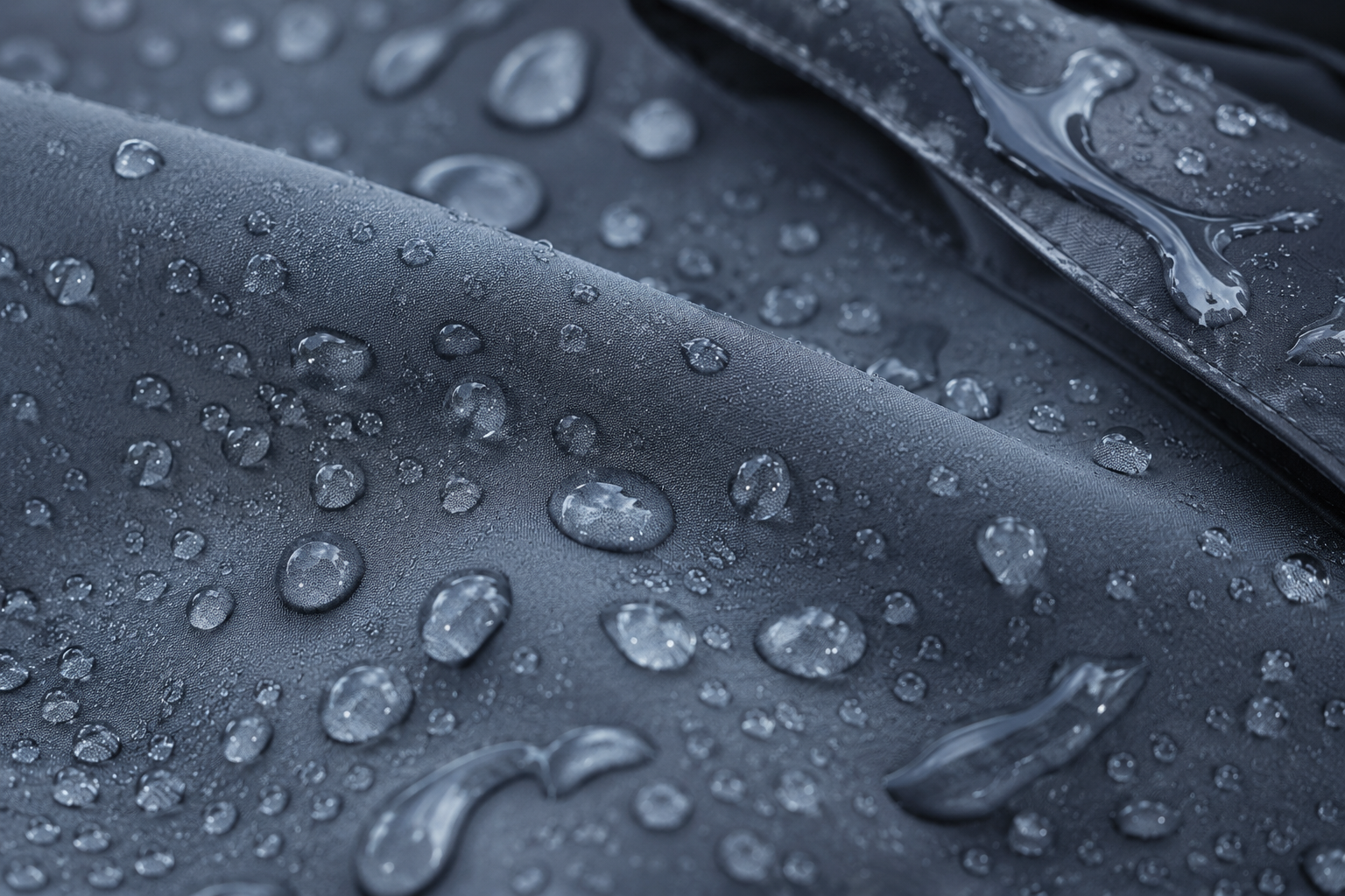 Water droplets beading on a matte waterproof fabric surface